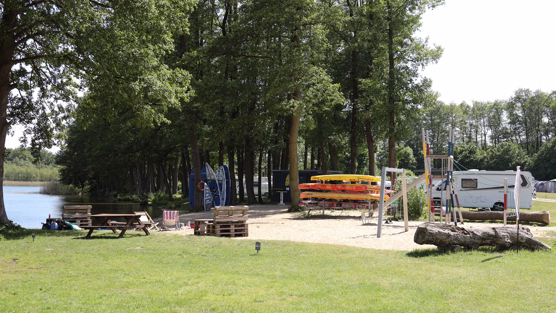 Louka s piknikovým místem a hřištěm na okraji lesa v kempu